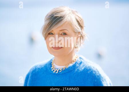 Portrait en plein air de belle femme de 55 - 60 ans, portant un pull bleu Banque D'Images