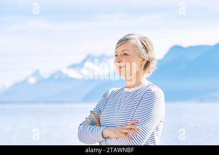 Portrait en plein air de belle femme mature posant à côté du lac, portant un t-shirt rayé bleu, mode de vie sain Banque D'Images