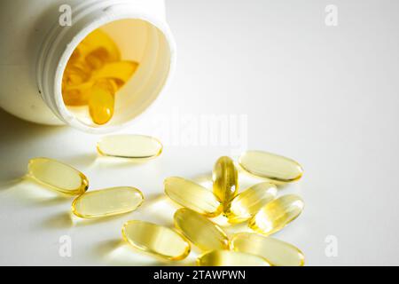 Ouvrez le flacon avec des gélules oméga-3. À côté du couvercle avec des capsules. Concept médical. Pile de capsules molles jaunes Omega 3 huile de poisson scutée à partir d'un W. Banque D'Images