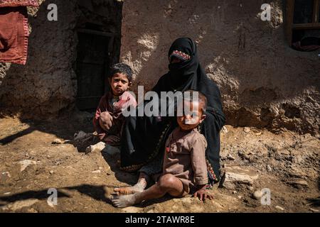 Une veuve triste dans le besoin, accompagnée de ses enfants, représente des familles afghanes confrontées à la pauvreté et aux difficultés | Refugee Family. Banque D'Images