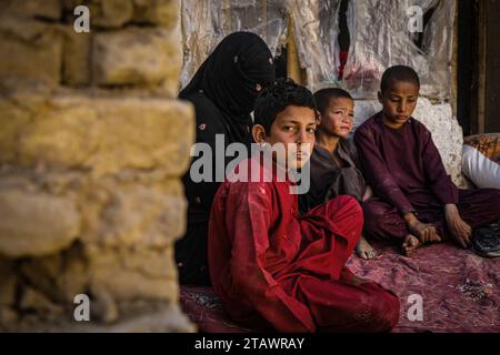 Une veuve triste dans le besoin, accompagnée de ses enfants, représente des familles afghanes confrontées à la pauvreté et aux difficultés | Refugee Family. Banque D'Images