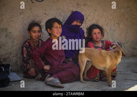 Une veuve triste dans le besoin, accompagnée de ses enfants, représente des familles afghanes confrontées à la pauvreté et aux difficultés | Refugee Family. Banque D'Images