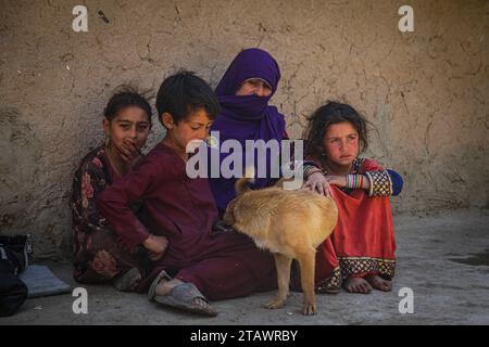 Une veuve triste dans le besoin, accompagnée de ses enfants, représente des familles afghanes confrontées à la pauvreté et aux difficultés | Refugee Family. Banque D'Images