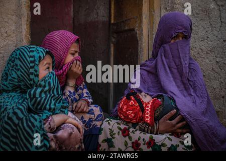 Une veuve triste dans le besoin, accompagnée de ses enfants, représente des familles afghanes confrontées à la pauvreté et aux difficultés | Refugee Family. Banque D'Images