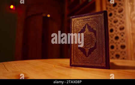Saint Al Coran avec calligraphie arabe écrite signifiant Al Coran sur fond noir. Copier l'espace et recadrer le fragment, Coran ouvert Banque D'Images