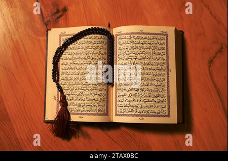Saint Al Coran avec calligraphie arabe écrite signifiant Al Coran sur fond noir. Copier l'espace et recadrer le fragment, Coran ouvert Banque D'Images