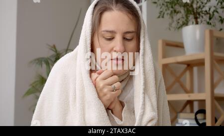 Femme couvrant dans la couverture se sentant froid dans son appartement sans chauffage. Concept de crise énergétique, factures élevées, économie et économiser de l'argent sur uti mensuel Banque D'Images