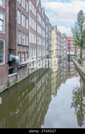 Pays-Bas. Façades arrière non frontales des maisons sur le canal d'Amsterdam. Reflets de maisons et d'arbres. Vélos sur le remblai Banque D'Images