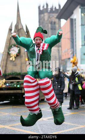 Manchester, Royaume-Uni. 3 décembre 2023. Manchester Christmas Parade est en cours dans les rues de la ville, avec tous les personnages habituels tels que le Père Noël et les elfes de la vie réelle. Un orchestre de pipe et un groupe de percussions Salva fournissent certains des sons avec les familles qui bordent les rues pour attraper un aperçu de certaines marionnettes géantes et le globe grandeur nature avec Snow Queen. Manchester, Royaume-Uni. Banque D'Images