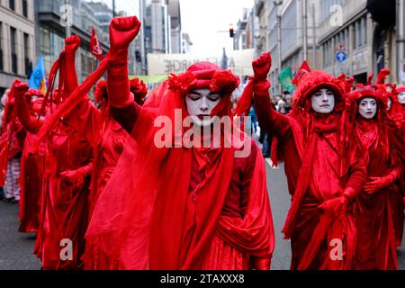 Bruxelles, Belgique. 03 décembre 2023. Les membres de extinction Rebellion Red Rebel Brigade prennent part à une manifestation climatique coïncidant avec la COP28 qui se tient à Dubaï à Bruxelles, en Belgique, le 3 décembre 2023. Crédit : ALEXANDROS MICHAILIDIS/Alamy Live News Banque D'Images