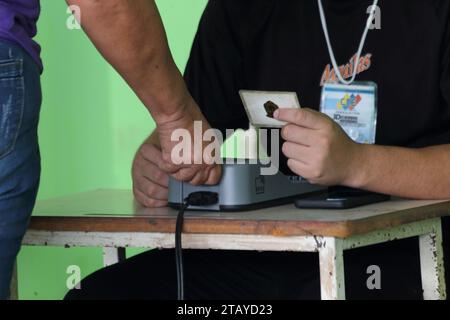 Maracaibo-Venezuela- 03-12-2023- Un électeur vérifie ses empreintes digitales pour pouvoir voter. Peu de Vénézuéliens ont répondu à l'appel pour le référendum organisé. Banque D'Images