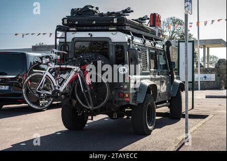 Vue arrière d'un beau Land Rover Defender SUV anglais vert équipé pour l'aventure avec les vélos suspendus à la porte arrière et la galerie de toit Banque D'Images