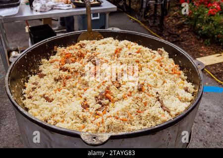 Cuisiner délicieux pilaf ouzbek traditionnel en chaudron Banque D'Images