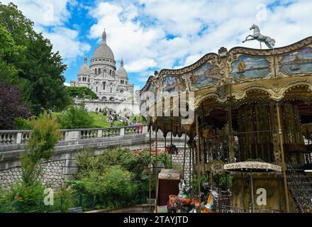 Paris, France. 1 juillet 2022. Photo gracieuse avec une belle vue sur la basilique du Sacré coeur, encadrée par la canopée d'arbres à gauche et le carrousel Banque D'Images