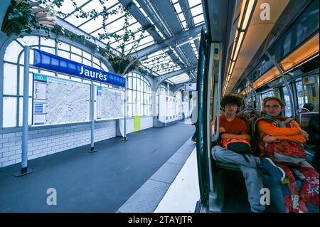 Paris, France. 1 juillet 2022. A la station de métro Jaures deux passagers dans le métro, un jeune homme et une femme d'âge moyen. Ils tiennent leurs sacs à dos Banque D'Images