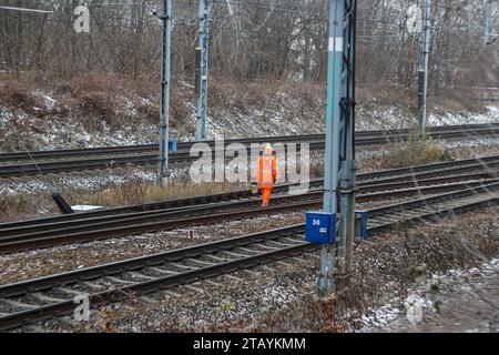 Varsovie, Mazowieckie, Pologne - 12.04.2023 : une personne portant une veste orange haute visibilité effectuant des travaux de maintenance sur une voie ferrée Banque D'Images