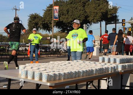 Des volontaires présents au Rock 'N' Roll Marathon à San Antonio, Texas, USA, le 3 décembre 2023. Le Rock 'N' Roll Marathon fait partie de la série Rock 'N' Roll Running qui a lieu aux États-Unis et à l'étranger. La série est une collection d'événements de course sur route détenus et exploités par le groupe concurrent du groupe IRONMAN, qui fait partie d'Advanced Publications. En 2014, Yvette Joy Liebesman a poursuivi Competitor Group, alléguant une violation de la Fair Labor Standards Act dans le traitement des volontaires dans leur St. Course Louis en 2012. Le recours collectif prétend que la société s'associe à des organismes de bienfaisance pour créer Banque D'Images