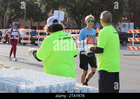 Des volontaires présents au Rock 'N' Roll Marathon à San Antonio, Texas, USA, le 3 décembre 2023. Le Rock 'N' Roll Marathon fait partie de la série Rock 'N' Roll Running qui a lieu aux États-Unis et à l'étranger. La série est une collection d'événements de course sur route détenus et exploités par le groupe concurrent du groupe IRONMAN, qui fait partie d'Advanced Publications. En 2014, Yvette Joy Liebesman a poursuivi Competitor Group, alléguant une violation de la Fair Labor Standards Act dans le traitement des volontaires dans leur St. Course Louis en 2012. Le recours collectif prétend que la société s'associe à des organismes de bienfaisance pour créer Banque D'Images