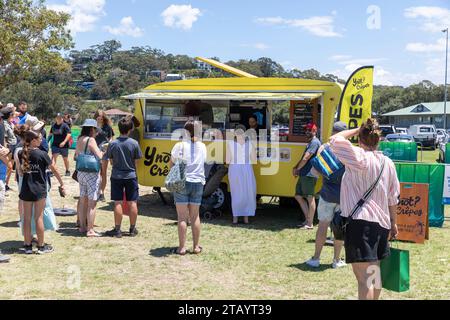 Australie, marché de Noël de Narrabeen à Sydney, les gens commandent et font la queue pour des crêpes à emporter de la nourriture de camion de nourriture de caravane jaune, Australie Banque D'Images