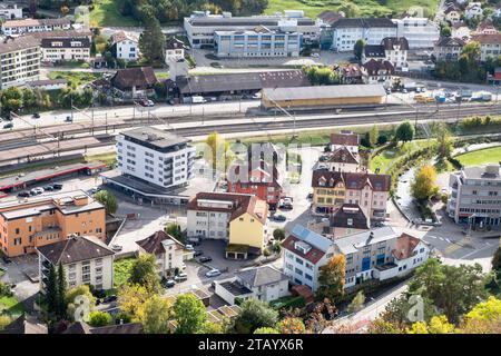 Réseau de rue et chemin de fer sur la gare avec maisons et bâtiments industriels dans le village suisse moyen ; vue aérienne. Vue de dessus de la petite ville suisse i Banque D'Images