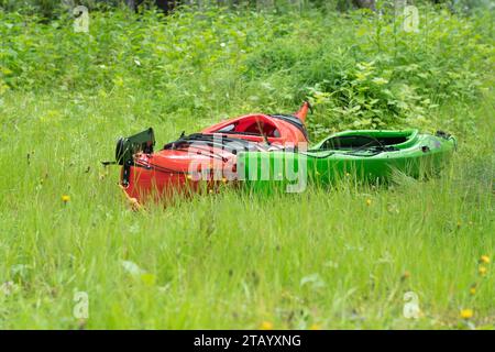 Deux kayaks - rouge et vert sont sur l'herbe verte. Gros plan photo de bas niveau Banque D'Images