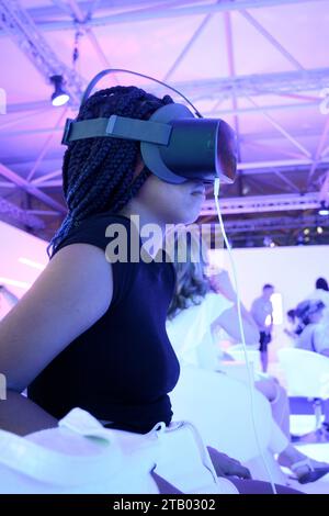 Fille de profil avec des tresses portant des lunettes de réalité virtuelle VR avec fond clair à la verticale Banque D'Images