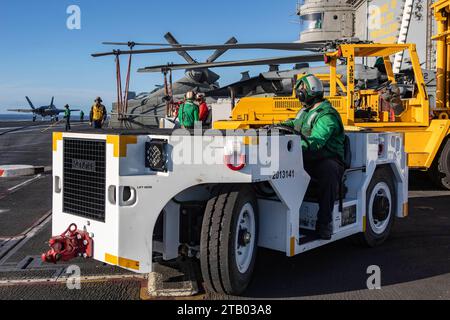 231202-N-LM220-1360 OCÉAN PACIFIQUE (2 décembre 2023) Aviation Boatswain’s Mate (équipement) l’aviateur Dustin May, de Phoenix, utilise un tracteur de remorquage sur le poste d’envol du porte-avions de classe Nimitz USS Abraham Lincoln (CVN 72). Abraham Lincoln mène actuellement des opérations de routine dans l'océan Pacifique. (Photo de l'US Navy par Clayton A. Wren, spécialiste des communications de masse de 2e classe) Banque D'Images