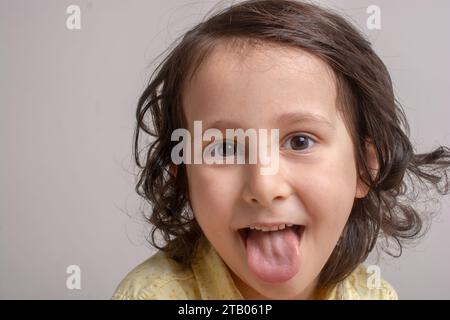 Closeup portrait of boy alittle coller sa langue out Banque D'Images