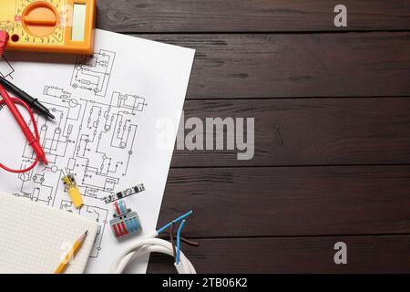 Schéma de câblage, papeterie de bureau, fils et multimètre numérique sur table en bois, vue de dessus. Espace pour le texte Banque D'Images