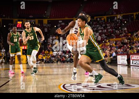 San Francisco met le garde Marcus Williams (55) en route vers le panier dans la première moitié du match de basket-ball de la NCAA contre Arizona State à Tempe, Banque D'Images