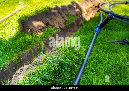 Pose précise du système d'irrigation dans la pelouse finie en été Banque D'Images