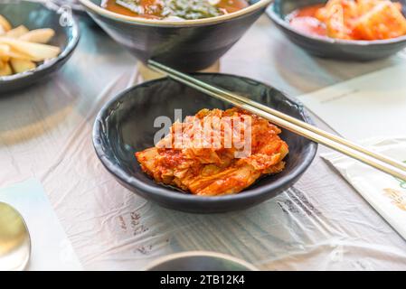 Fermé de chou Kimchi dans un bol avec des baguettes en acier inoxydable, nourriture coréenne Banque D'Images