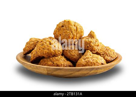 Pile de délicieux biscuits croustillants à la meringue à la noix de coco maison dans une assiette en bois isolée sur fond blanc avec chemin de détourage. Banque D'Images