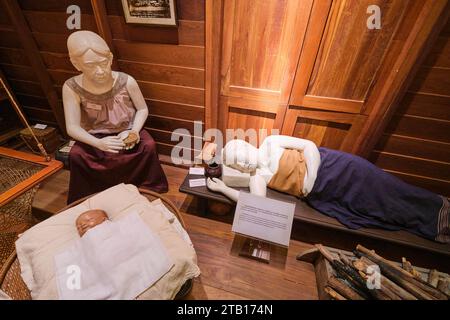 Une infirmière mouillée s'occupe d'un nouveau-né pendant que la jeune mère dort. Dans une récréation d'une infirmière humide à domicile avec une nouvelle mère, un enfant, un bébé. Une partie du SIR Banque D'Images