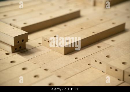 Gros plan des pièces en bois dans les grandes installations de fabrication de meubles. Pièces en bois pour la production de chaises dans l'entrepôt d'une usine de meubles Banque D'Images