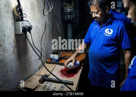 Maldives. 04 décembre 2023. Un travailleur peint des boulons en spray dans un atelier de réparation dans la rue de Malé. Vie quotidienne à Malé, aux Maldives, capitale de la nation insulaire de l’océan Indien, dont l’économie dépend fortement du tourisme. La population du pays comprend de nombreux ressortissants étrangers travaillant dans des pays du monde entier, y compris les Philippines, le Myanmar, le Sri Lanka et l'Inde, et sa population est majoritairement musulmane. Crédit : Matt Hunt/Neato/Alamy Live News Banque D'Images