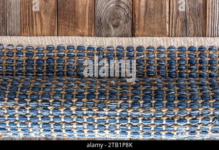 Tapis en denim géométrique tissé à la main sur plancher en bois. Banque D'Images