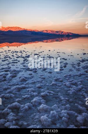 Montagnes reflétées dans l'eau lever de soleil Badwater Basin Death Valley Banque D'Images