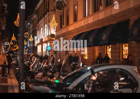 Fond flou des lampadaires de noël avec des gens se promenant avec des sacs à provisions à Milan, Italie 2.12.2023 Banque D'Images