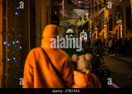 Fond flou des lampadaires de noël avec des gens se promenant avec des sacs à provisions à Milan, Italie 2.12.2023 Banque D'Images