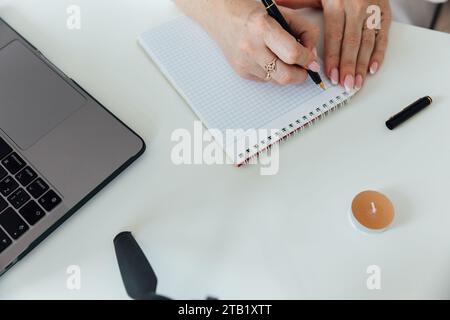 Les mains féminines sur le bureau prenant des notes sur le papier Banque D'Images