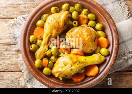 Poulet algérien aux olives et carotte Tajine Zitoune gros plan sur une table en bois. Vue de dessus horizontale Banque D'Images