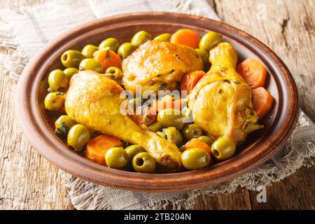 Tajine zitoune est un mélange de poulet de légumes ad épices cuisine en gros plan sur table en bois. Horizontal Banque D'Images
