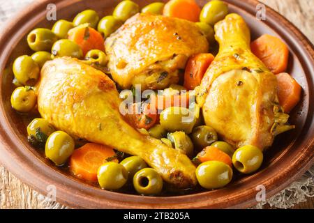 Poulet algérien aux olives et carotte Tajine Zitoune gros plan sur une table en bois. Horizontal Banque D'Images
