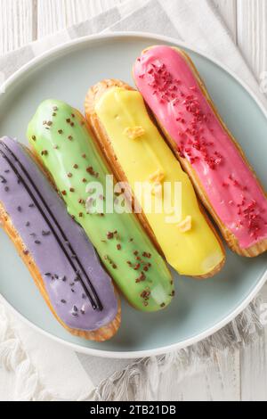 Groupe de dessert français Eclair closeup sur plaque sur fond en bois. Vue verticale de dessus Banque D'Images