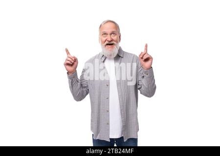 joli grand-père actif inspiré avec barbe blanche et moustache habillé en chemise rayée et jeans Banque D'Images