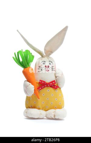 Joyeux lapin de Pâques à la main dans la robe jaune sur fond blanc. Jouet lapin de Pâques en tissu naturel Banque D'Images