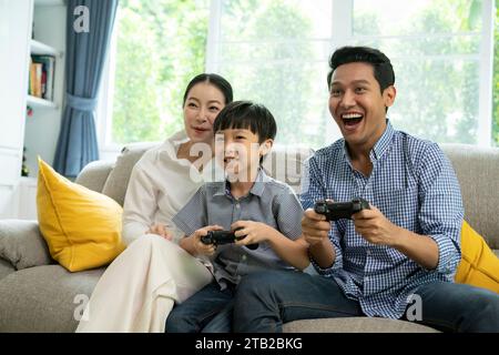 Divertir la technologie style de vie familial, jouer à un jeu en ligne avec plaisir et excité, acclamer la victoire ensemble à la maison Banque D'Images
