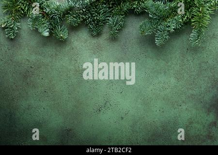 Composition de Noël. Branches de sapin de Noël avec des pommes de pin et des papiers boules rustiques sur fond rustique en béton vert vieux. Voeux de Noël Banque D'Images