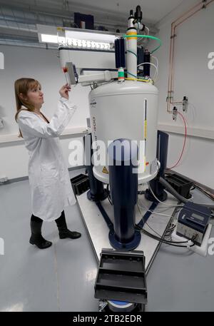 Rostock, Allemagne. 04 décembre 2023. Ulrike Jost, une chimiste, place un échantillon dans un crible alimentaire à l'Office d'État pour l'agriculture, la sécurité alimentaire et la pêche (Lallf). Le spectromètre à résonance magnétique nucléaire, qui coûte un million d’euros, permet d’analyser avec précision des échantillons alimentaires. À l'avenir, une analyse prendra environ 30 minutes au lieu des trois jours précédents et permettra également de déterminer le pays d'origine exact. Crédit : Bernd Wüstneck/dpa/Alamy Live News Banque D'Images